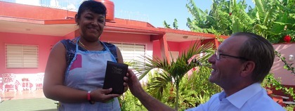 Jan geeft zijn eigen Bijbel aan de werkster in het hotel, Die wel naar de kerk gaat maar graag een eigen Bijbel heeft.